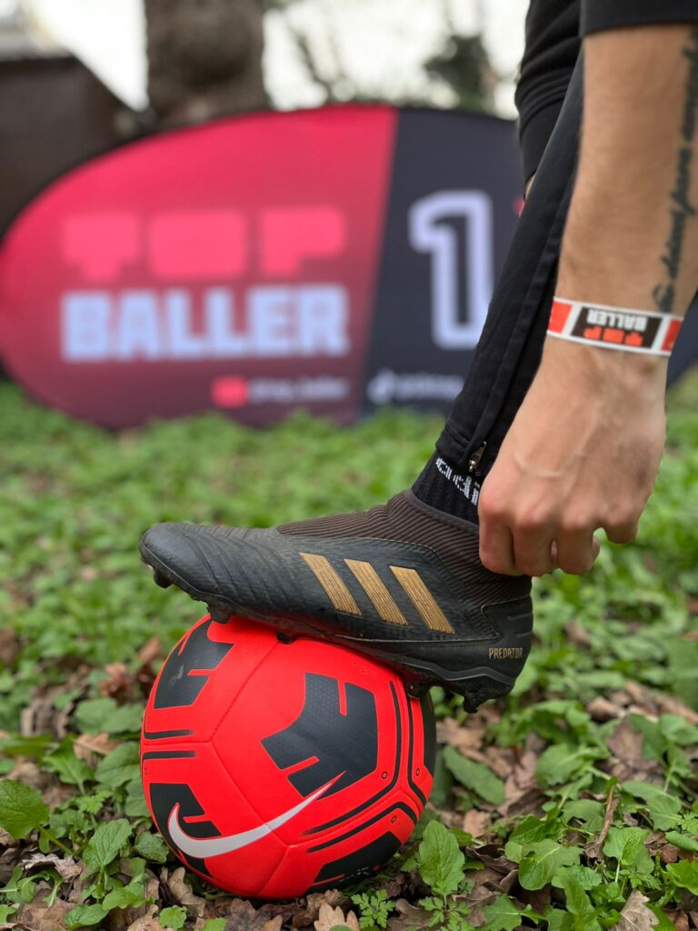 Player getting ready to kick the ball with Top Baller merch in the background
